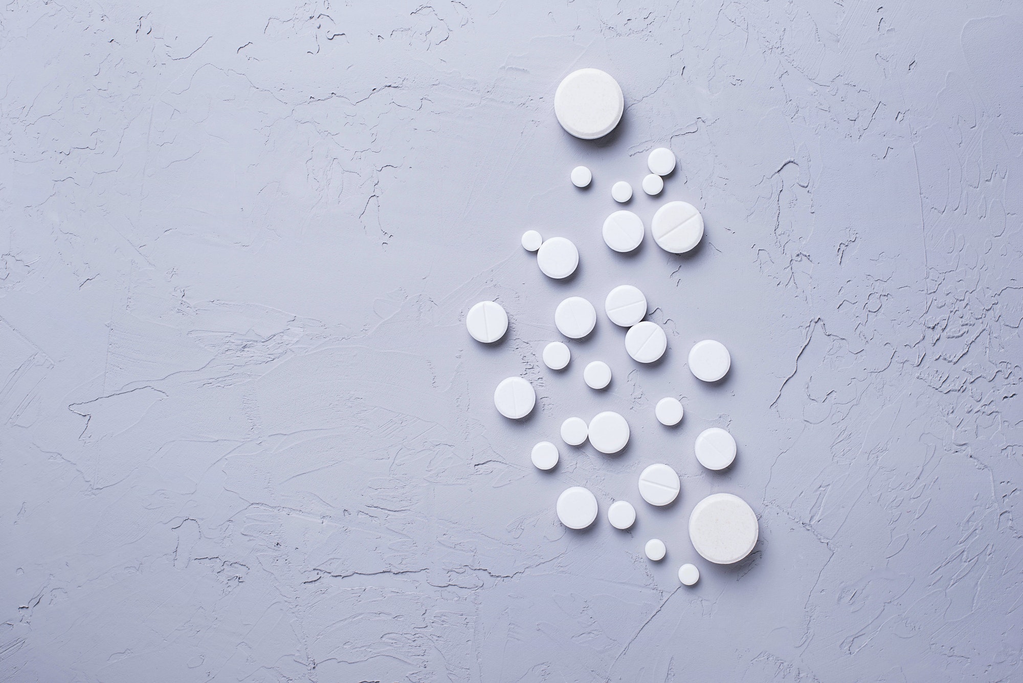 Different pills and tablets on grey background