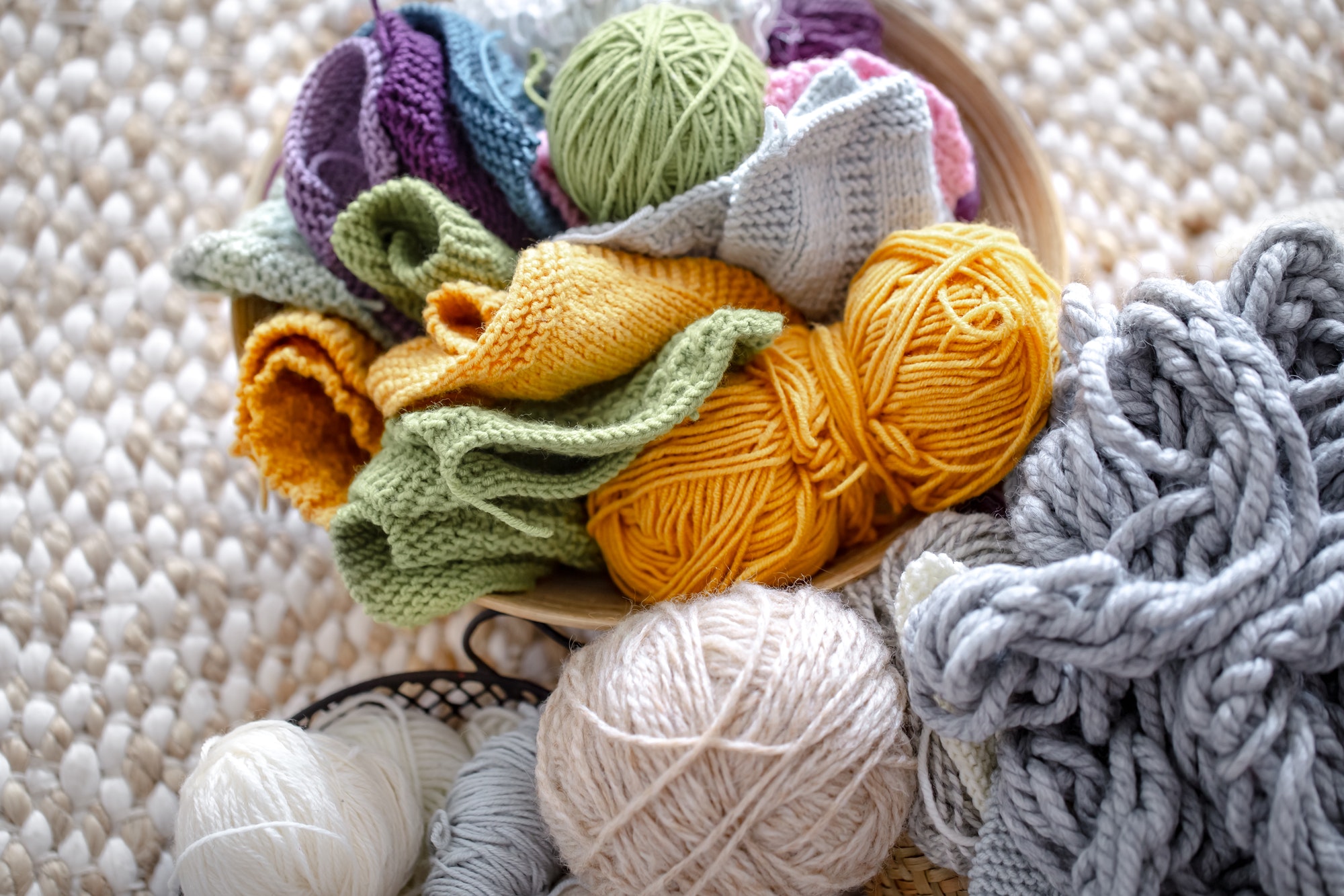 Multicolored balls of thread for knitting in the basket.