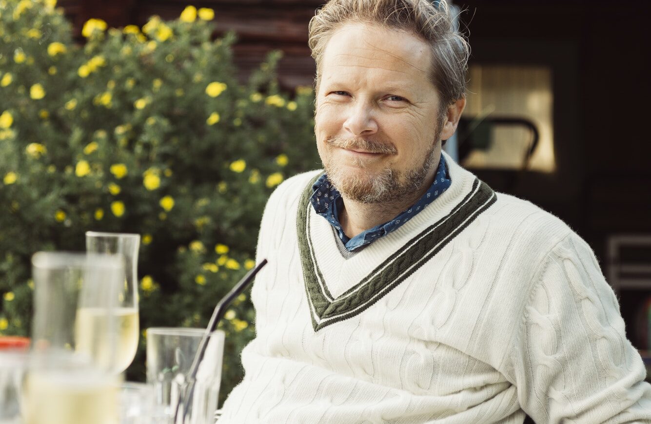 Portrait of mature man sitting at table in garden