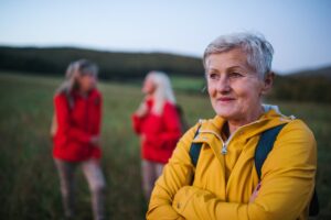 Senior women friends on walk outdoors in nature at dusk