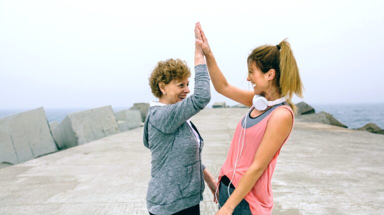 Senior sportswoman and female friend high five