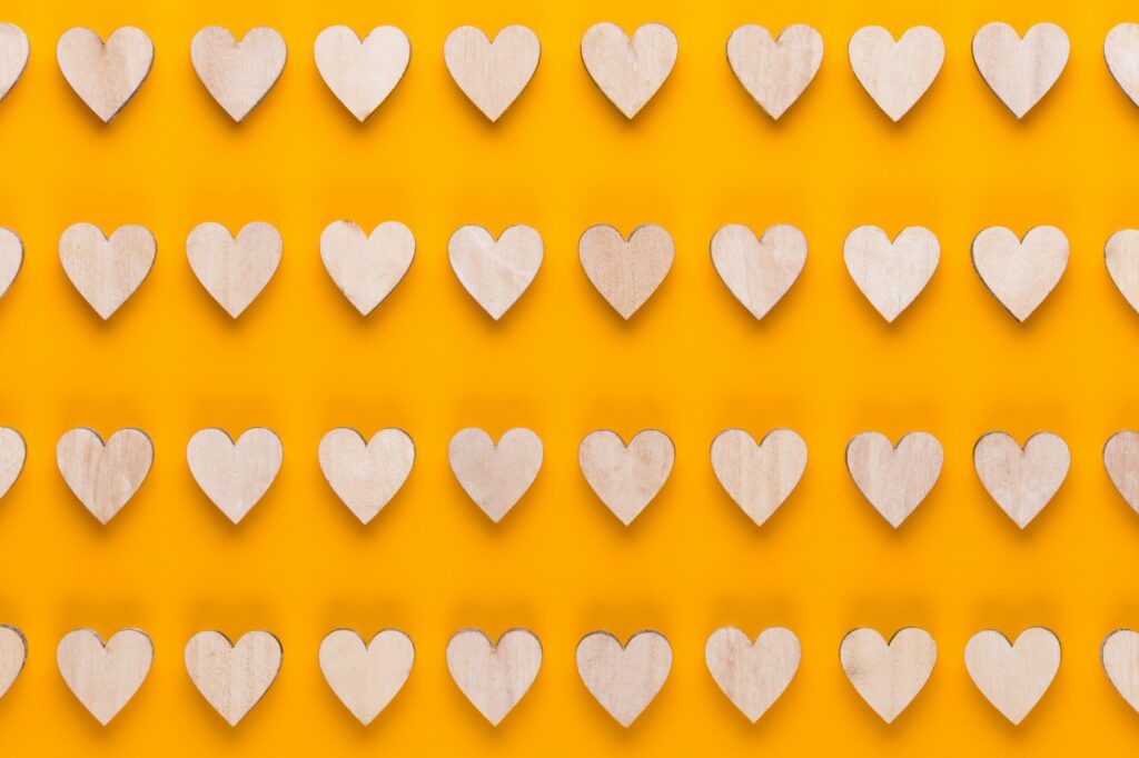 Small wooden hearts on a yellow background.