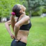 Woman suffers from back pain during sports activity